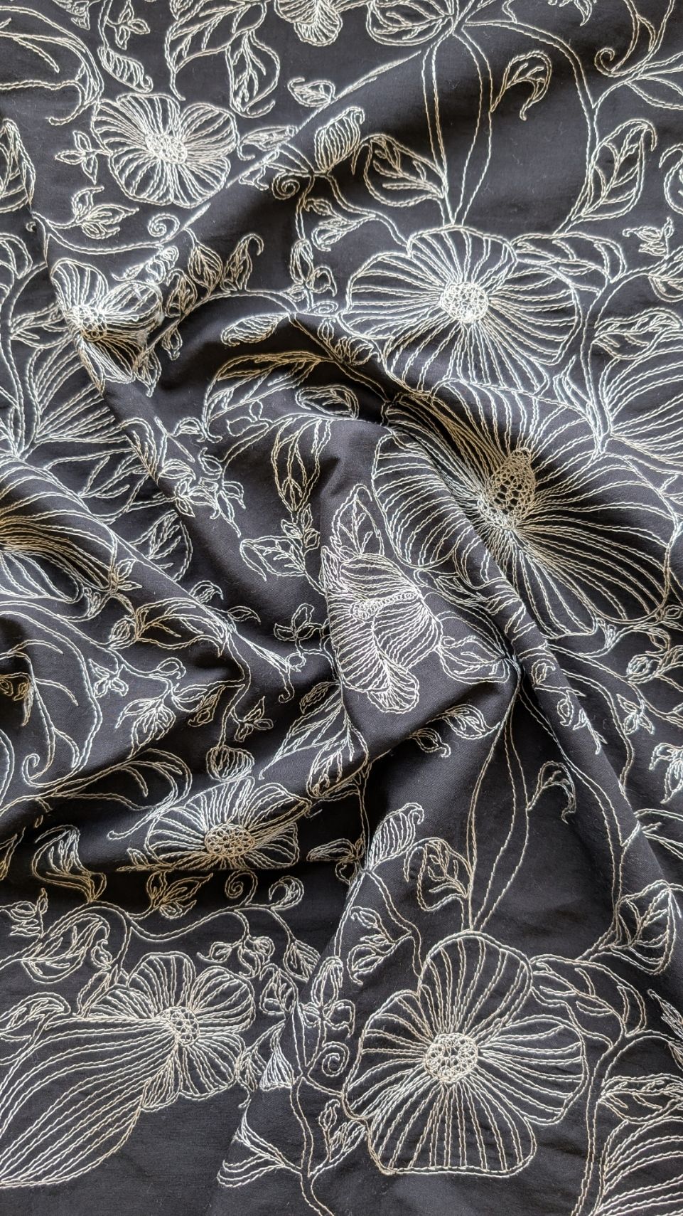 Coton noir avec broderie écrue, idéal pour vêtements et créations élégantes.